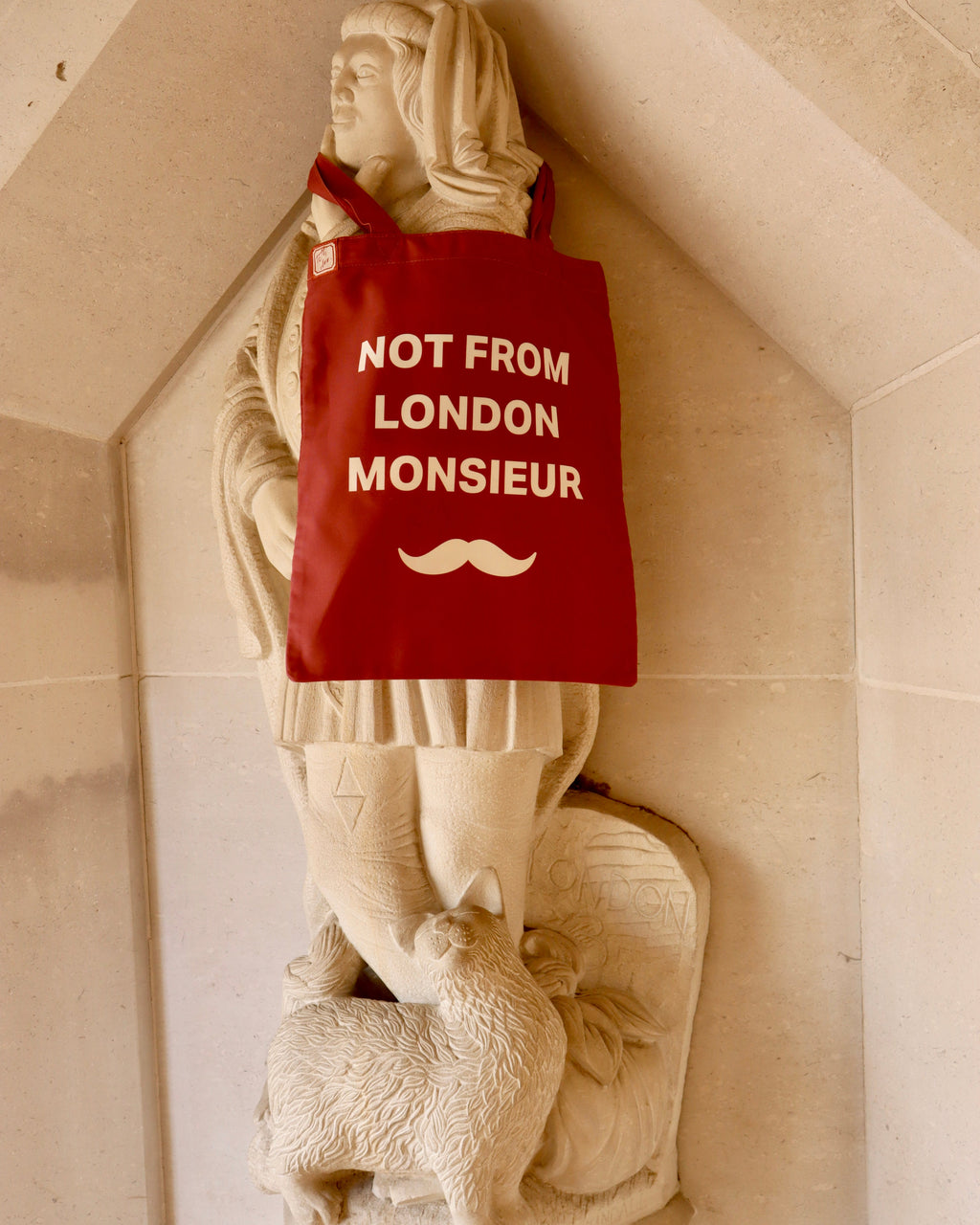 Monsieur tote hung on a stone statue