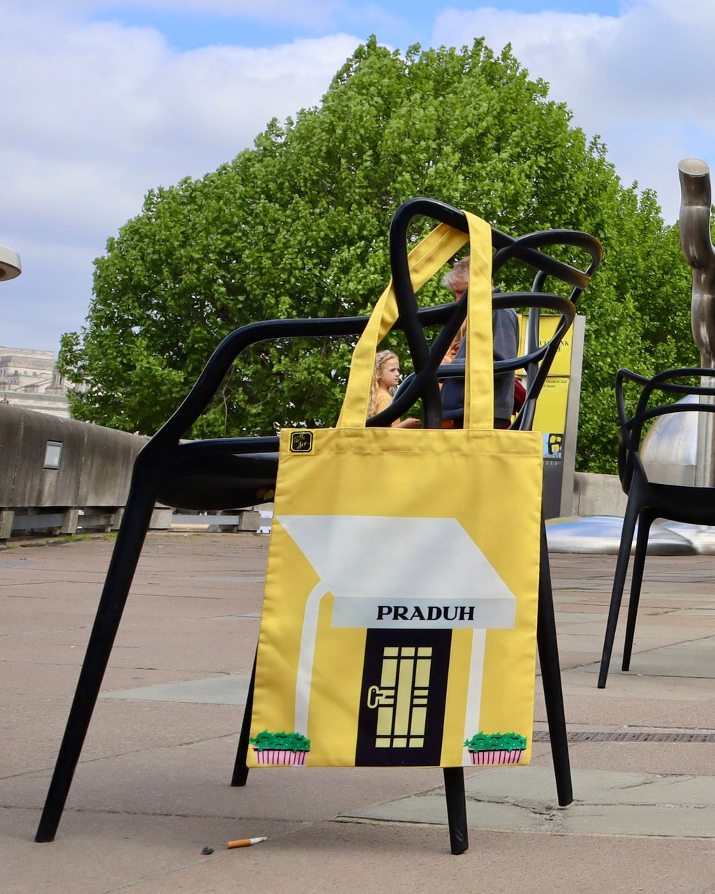 Capri tote hung on a black chair outdoors