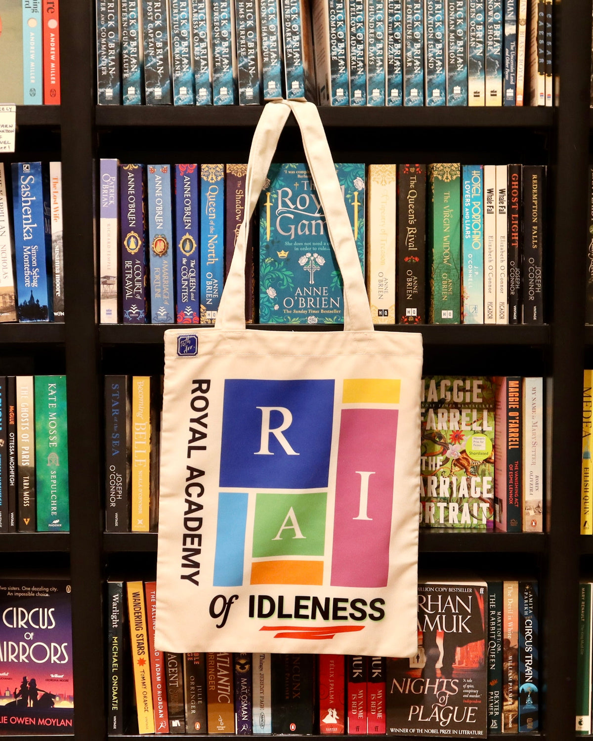 RAI tote hanging on a bookshop shelf